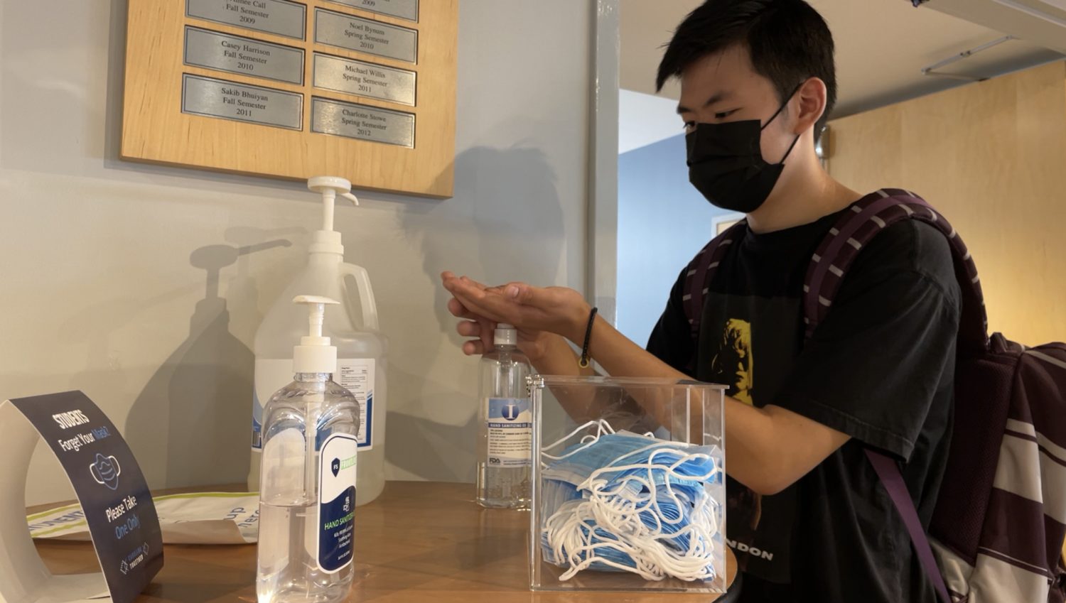 Image of Jerry Xu on campus sanitizing his hands